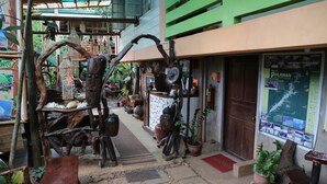 A narrow indoor corridor with wooden sculptures and a map of Palawan, Philippines. - Victoria Guest House and Cottages (Puerto Princesa)