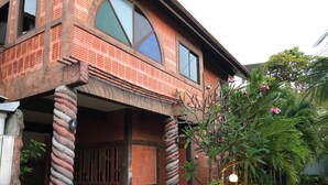 A two-story house with a brick exterior, large windows, and a porch with a spiral column. - Villa Kamala Beach (Kamala)