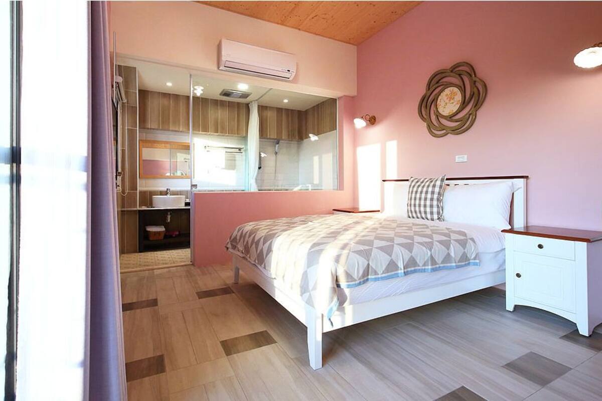 A bedroom with a bed, bedside table, and a mirror.