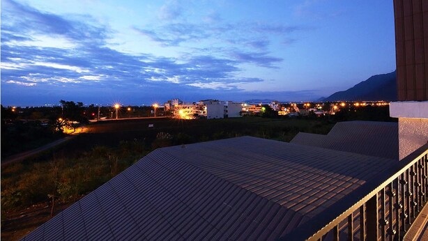 A rooftop terrace with a view of a cityscape at dusk. - B&B Mountain View (Xincheng)