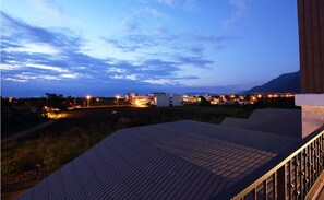 A rooftop terrace with a view of a cityscape at dusk. - B&B Mountain View (Xincheng)