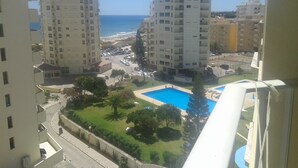 A view of a residential area with two high-rise buildings, a swimming pool, and a clear view of the sea. - T1 - Sea View Balcony (Armação de Pêra)