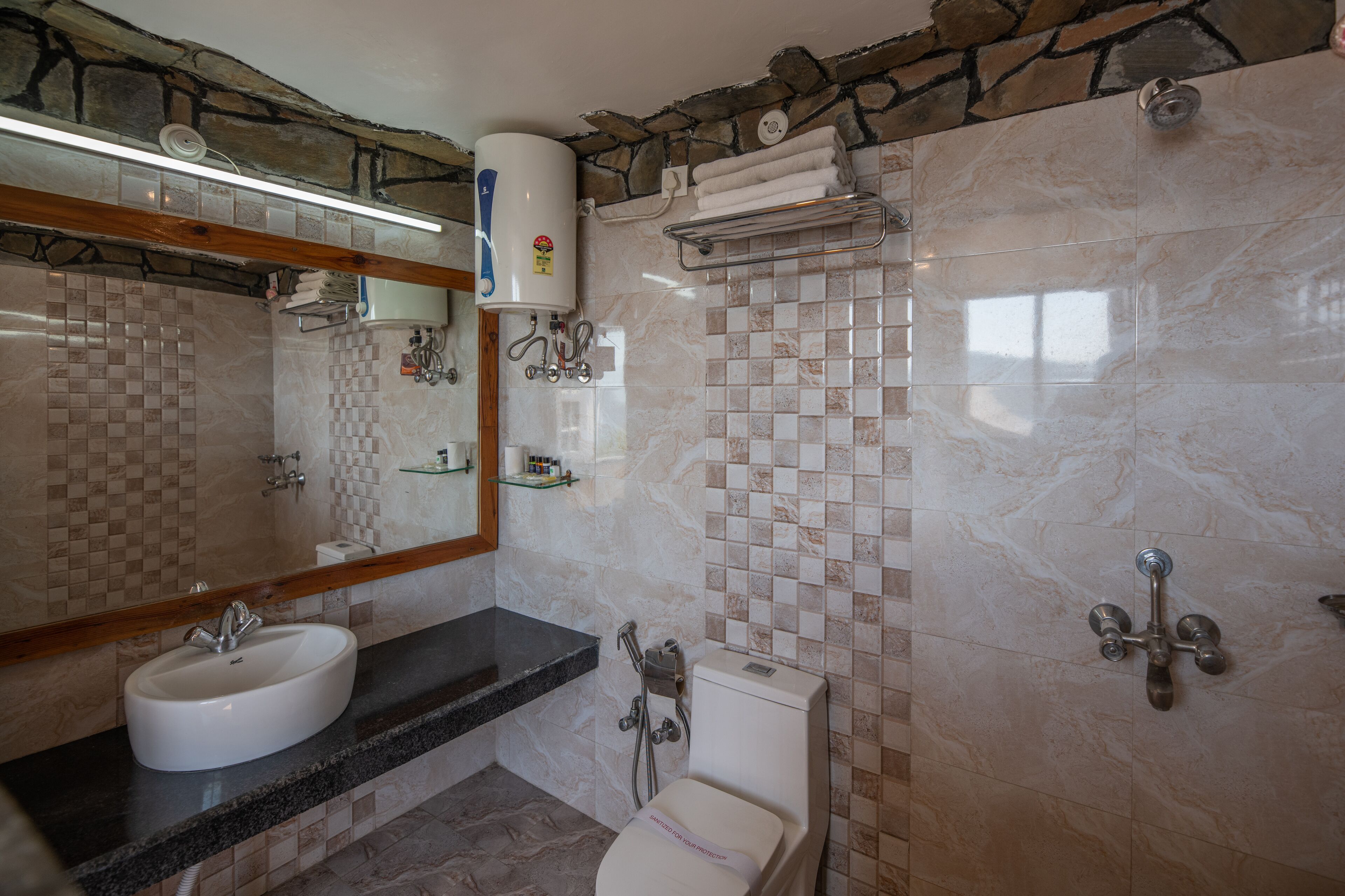 Un baño con dos lavamanos, un inodoro, una ducha y un perchero para toallas.