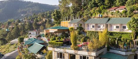 Un hotel en una ladera con varias edificaciones, cada una con techo verde y rodeada de abundante vegetación.