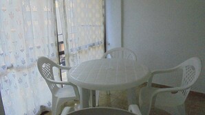 A small, round table with four white plastic chairs. - Los Labradores (Peñiscola)