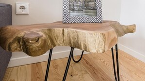 A wooden table with a unique design, featuring a single leg and a picture frame on top. - Freixo - River View Apartment (Oporto)