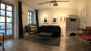 Una sala de estar con sofá, una mesa, una lámpara y una chimenea.