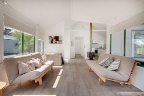 A spacious living area with two sofas, a coffee table, and a fireplace.