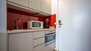 Eine kleine Küche mit Mikrowelle, Backofen und Spüle.