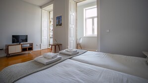 Ein Hotelzimmer mit einem großen Bett, einem Fernseher, einem Schreibtisch und einem Stuhl.