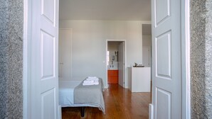 Ein Schlafzimmer mit einem Bett, einem Nachttisch und einer Tür zu einem Badezimmer.