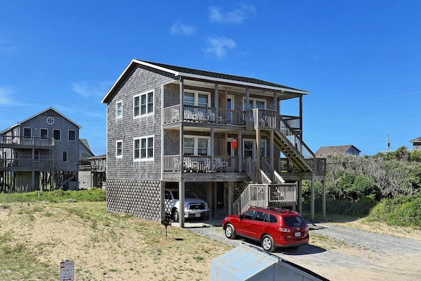 Un bâtiment à deux étages doté d’un balcon à l’étage supérieur, d’un porche avant couvert et d’un garage.