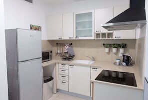 Apartamento, vistas a la ciudad | Cocina básica privada | Frigorífico, microondas, placa de cocina y cafetera o tetera