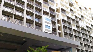 A multi-story building with a sign reading "Shore" in front. - 1 BR Fully Furnished Condo Across MOA with Pool and Parking - Shore Bldg B, 1244 (Pasay City)