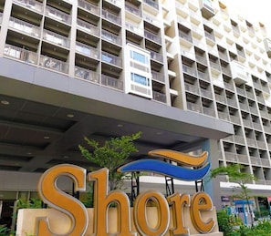 A multi-story building with a sign reading "Shore" in front.