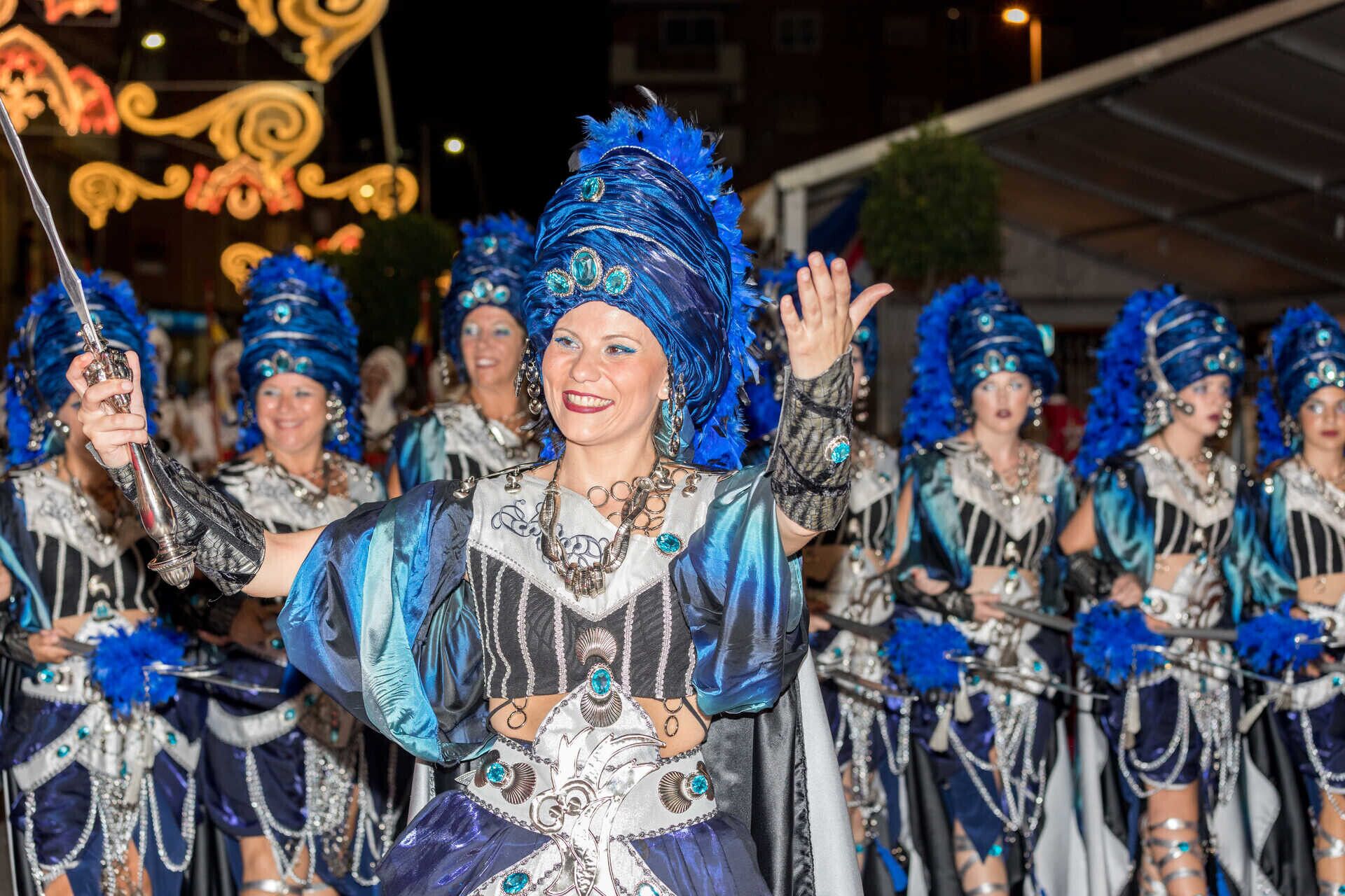 Un gruppo di persone in costumi elaborati, con decorazioni e accessori ricercati.