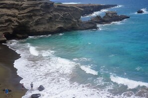 Paesaggio costiero con scogliere rocciose e acque blu cristalline.