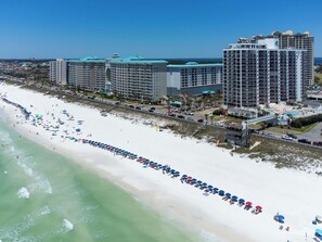 A beachfront hotel with multiple high-rise buildings, a long stretch of beach with umbrellas, and a clear view of the ocean. - Ariel Dunes I🐚Seascape Resort👙Gulf Views🌊Golf⛳ (Miramar Beach)