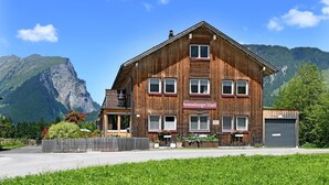 A wooden building with a sign reading 'Ferienwohnungen Schantl' in front of a mountain.
