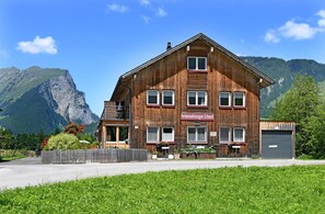 Un edificio de madera con un cartel que dice 'Ferienwohnungen Schantl' frente a una montaña.