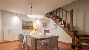 A dining area with a table, chairs, a vase with flowers, and a staircase. - San Frediano House, beautiful apartment in Via Romana by Mmega (Firenze)
