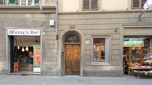 A street view with Jessy's Bar, a wooden door, and a fruit stand. - San Frediano House, beautiful apartment in Via Romana by Mmega (Firenze)