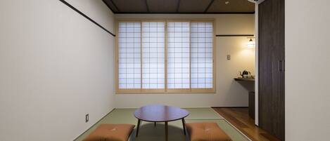 A traditional Japanese room with tatami flooring, a low table, and shoji sliding doors.