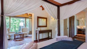 Une chambre à coucher avec un lit, une table de chevet, une chaise et une fenêtre.