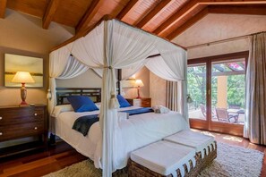 Una cama con dosel y cuatro columnas con vistas al exterior.