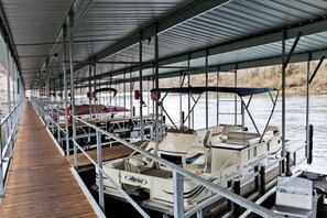 A covered dock area with boats and a wooden walkway.