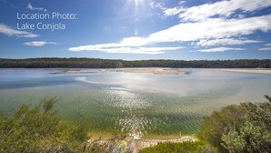 A clear view of Lake Conjola with calm waters and a bright sun. - liandys@lakeconjola - close to lake, dog friendly (Lake Conjola)