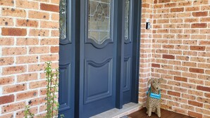 A brick exterior with a dark blue door, a potted plant, and a welcome sign on a dog. - liandys@lakeconjola - close to lake, dog friendly (Lake Conjola)