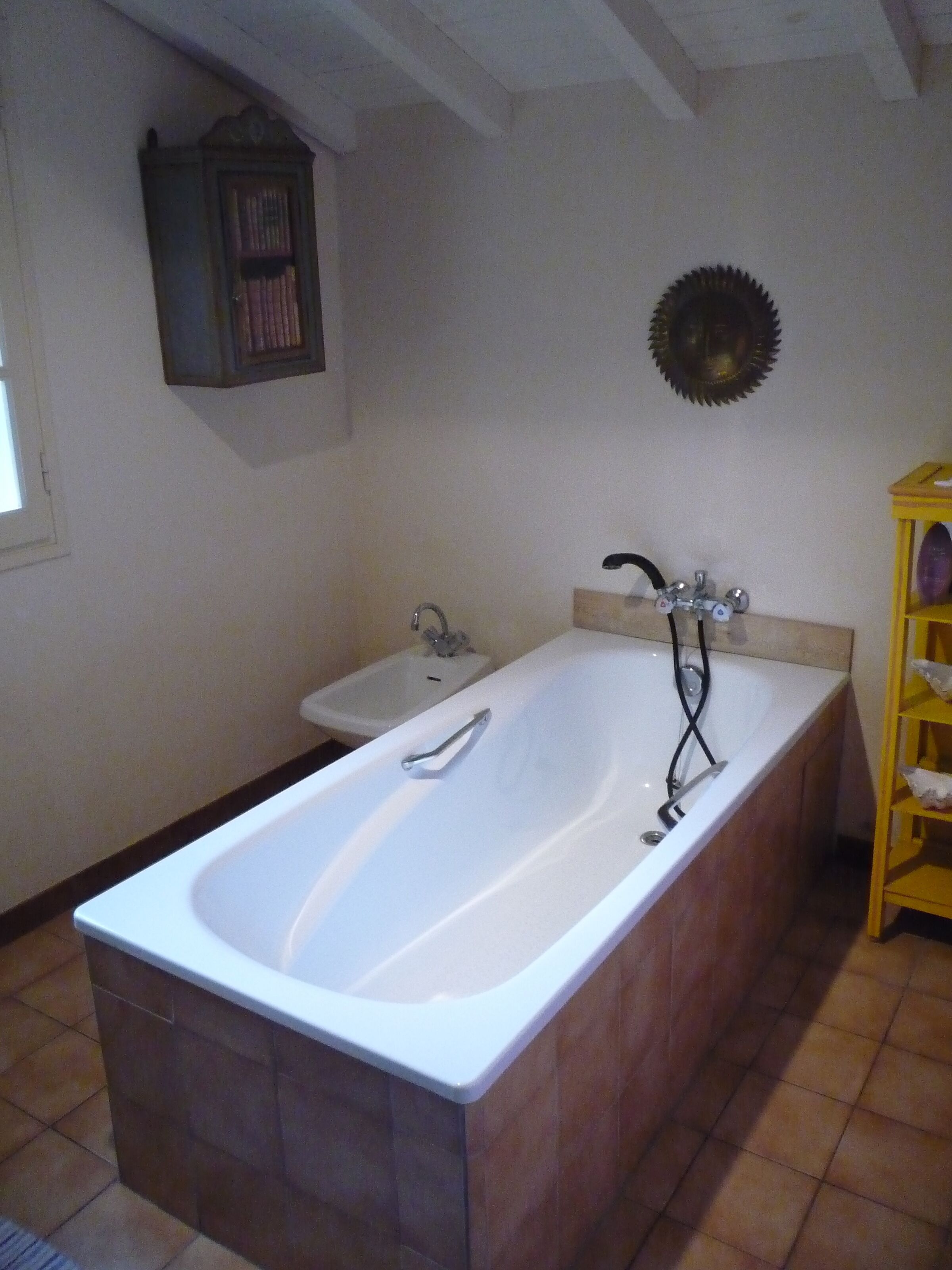 Ein Badezimmer mit Badewanne, Waschbecken und einem Waschtisch mit Regalen.