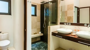 A modern bathroom with two sinks, a glass-enclosed shower, and a small window. - Mak Nuk Village-Studio-Swimup (Tulum)