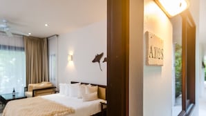 A hotel room with a large bed, a desk, and a chair. There is a wall-mounted sign with the letters "A102S". - Mak Nuk Village-Studio-Swimup (Tulum)