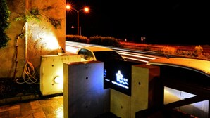 Een parkeerplaats bij nacht met een bord dat de ingang van een parkeergarage aangeeft.
