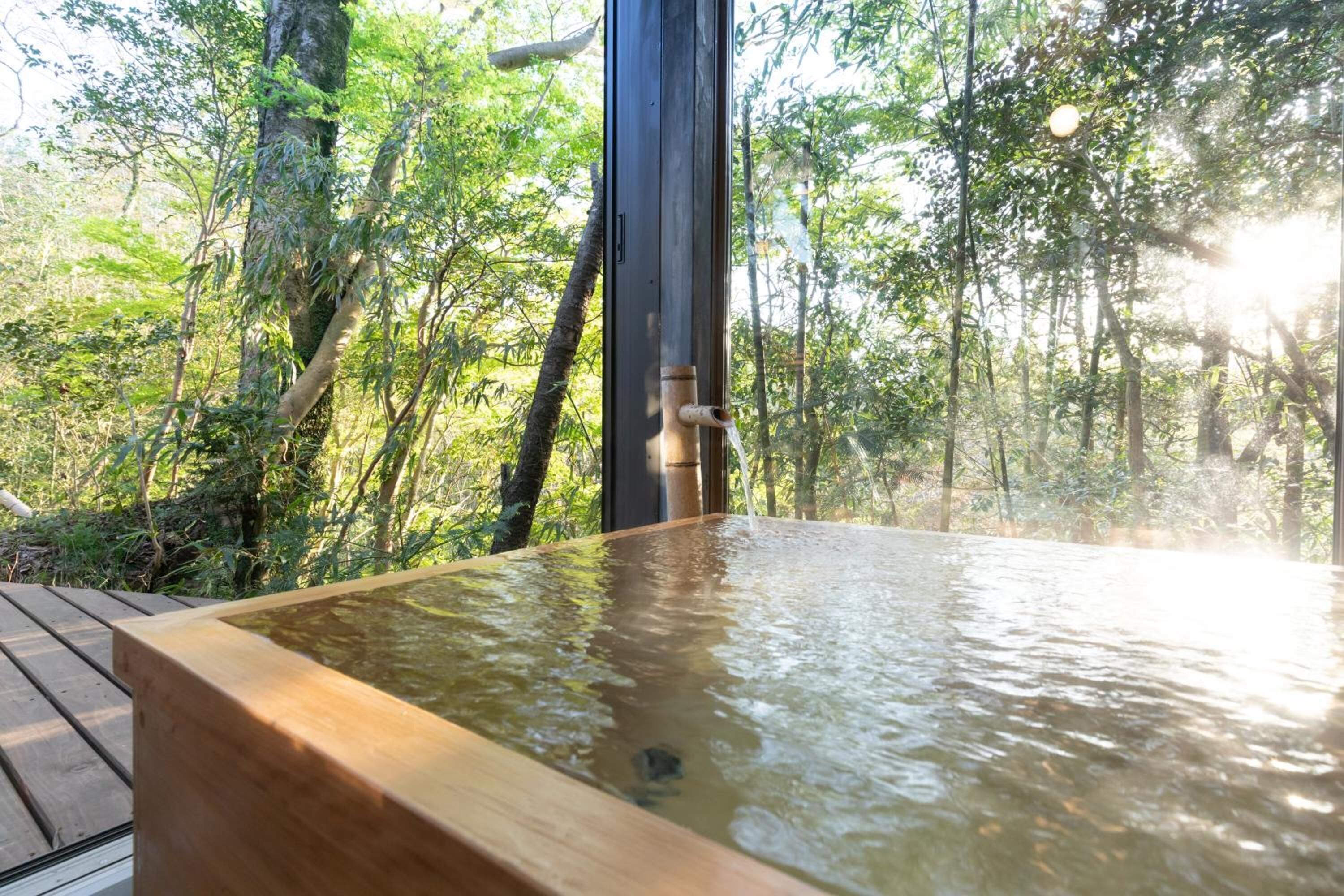 A hot tub in a forested area with a wooden deck.