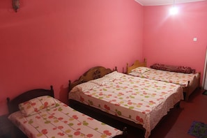 A room with three beds, each with a floral-patterned bedspread.