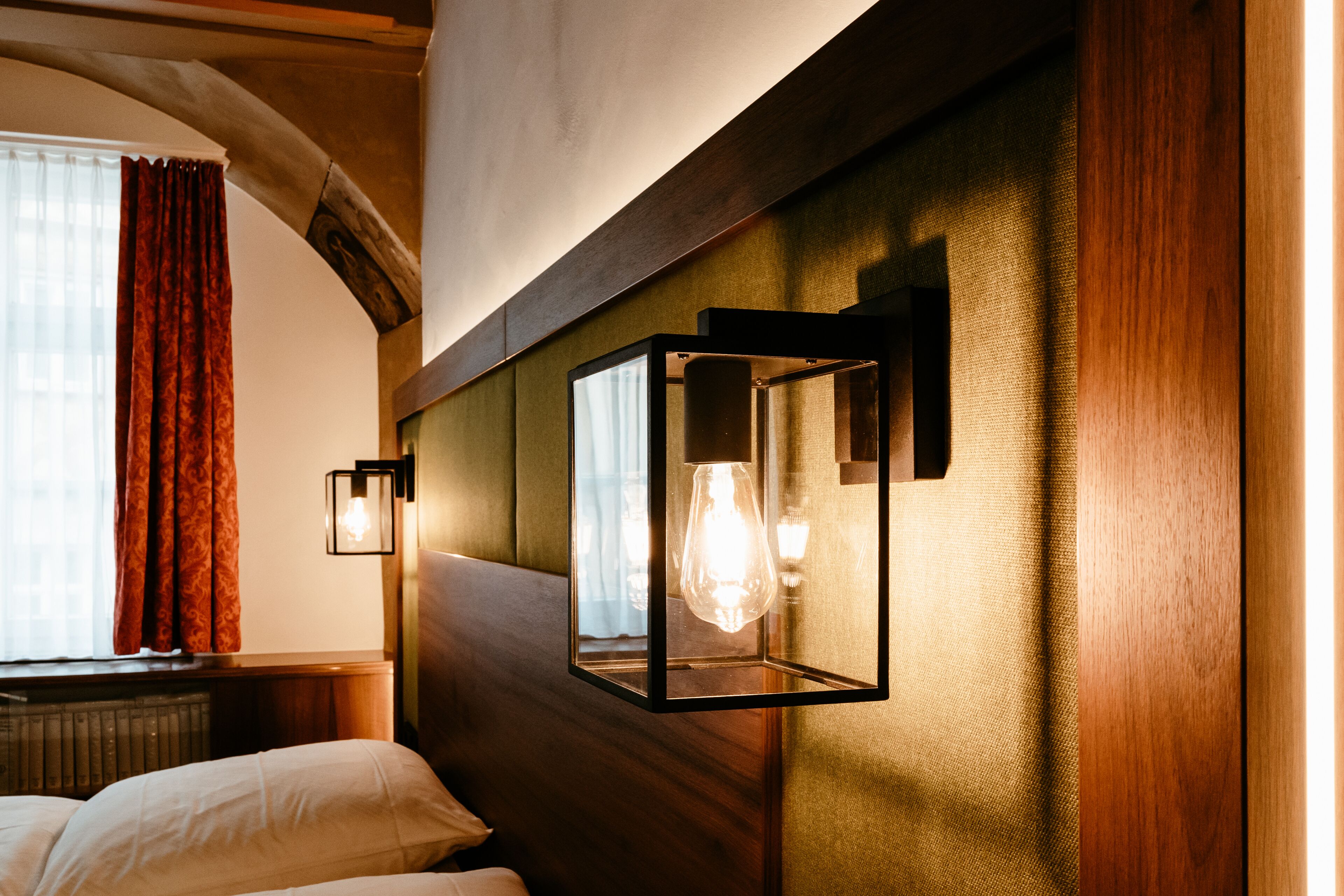 A hotel room with a wooden headboard, a bed with white linens, and two wall-mounted light fixtures. - Hotel-Gasthof Goldener Greifen (Rothenburg ob der Tauber)