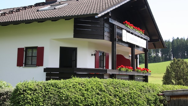 A traditional chalet with a balcony, a chimney, and a sign indicating it is a Landhaus. - Landhaus Seehof (Fuessen)