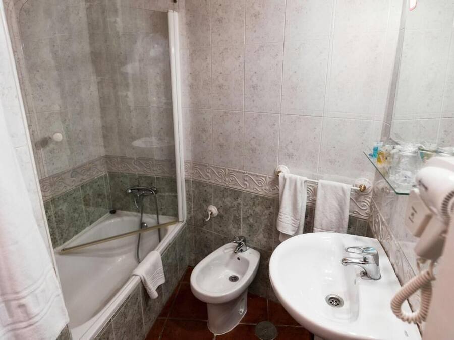 A bathroom with a bathtub, a bidet, and a sink.
