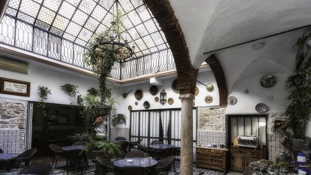 Un café con terraza, suelo de baldosas y techo de cristal.