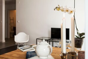 A wooden table with a white teapot, two candles, and an orchid. - Scandinavian Apartment in Cascais (Cascais)