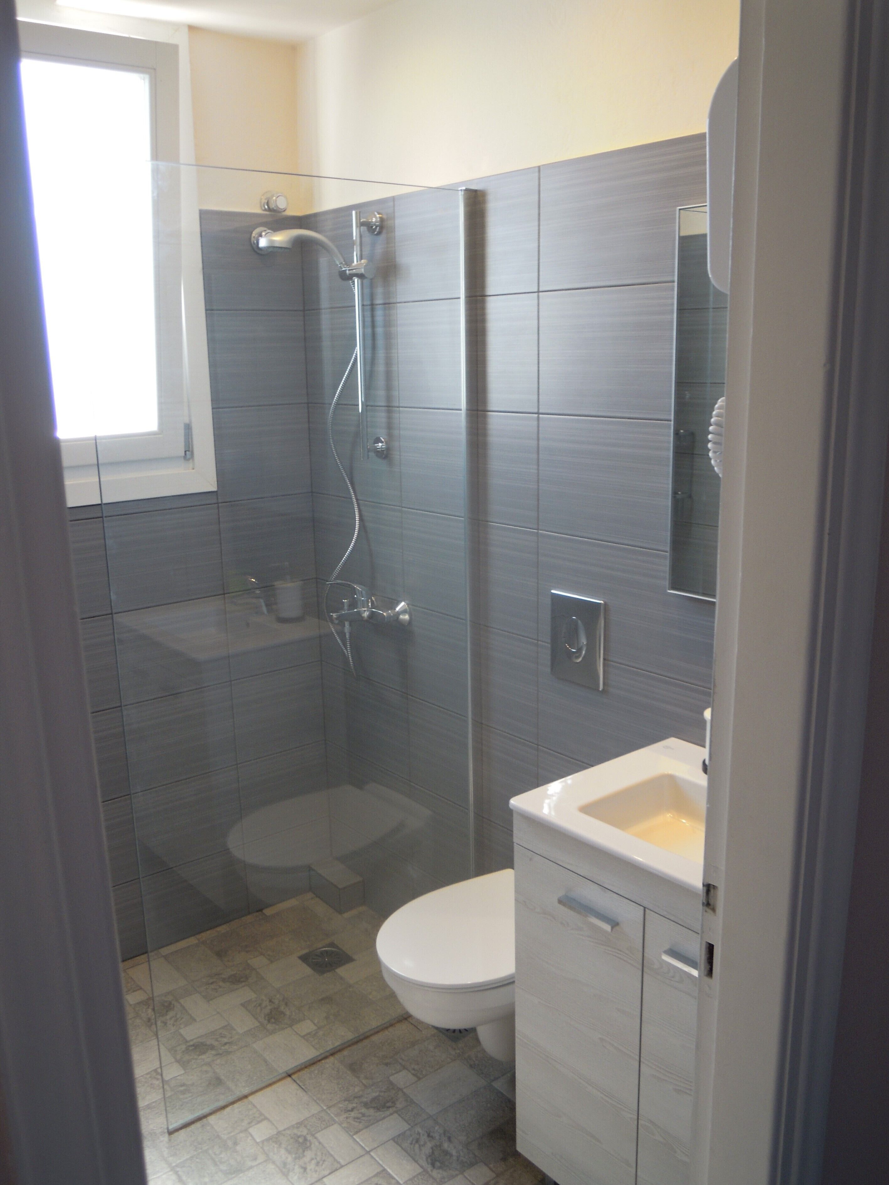 Une salle de bain moderne avec une douche à parois de verre, des toilettes et un lavabo.