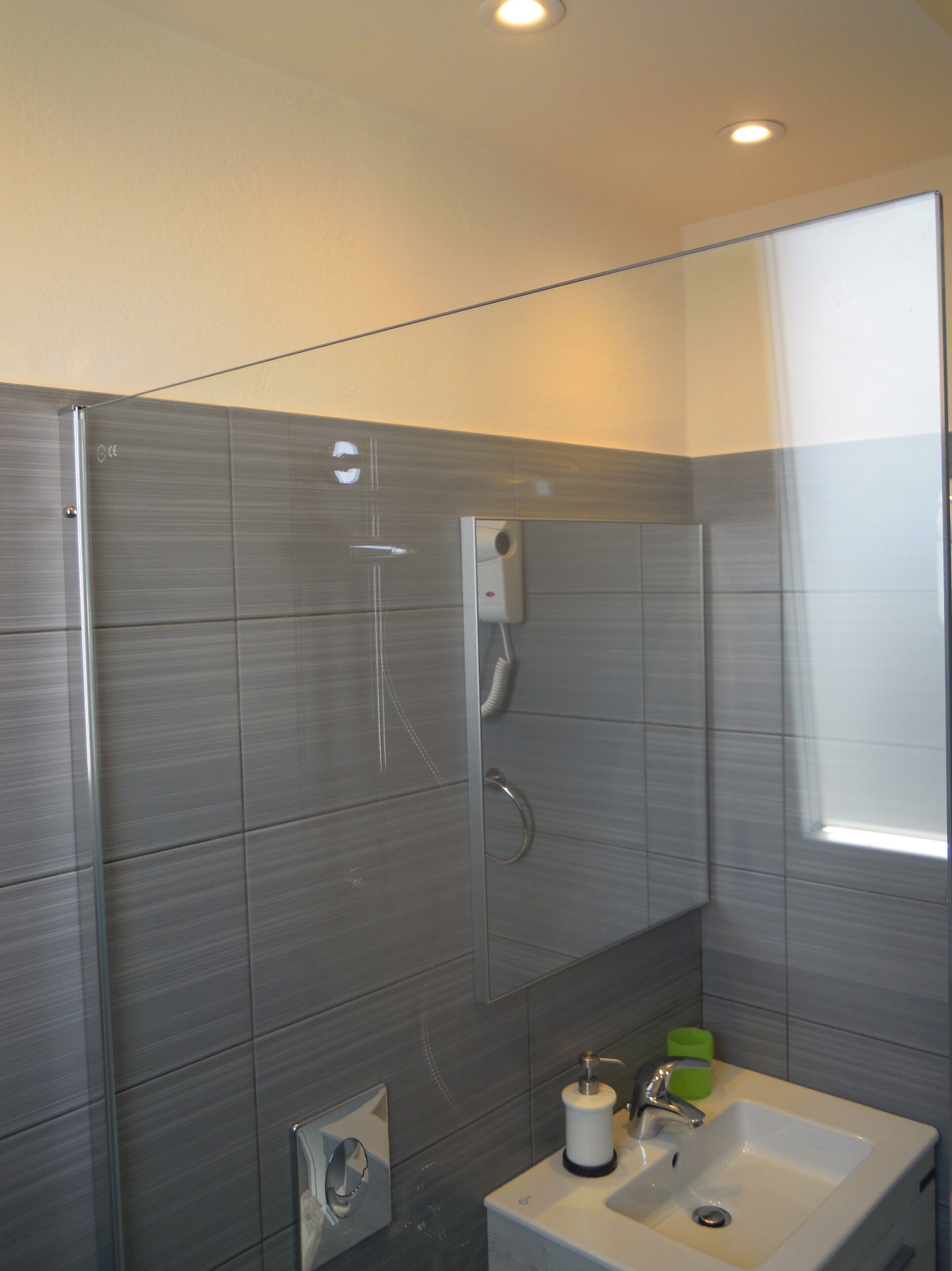 A modern bathroom with a glass shower enclosure, a built-in sink, and a toilet.
