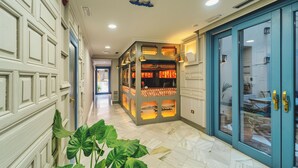 Un pasillo con una mesa de recepción, una puerta azul y una planta.
