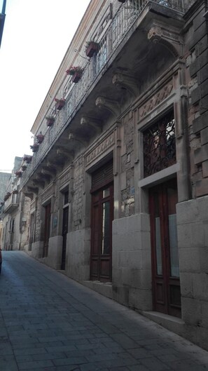 A historic building with ornate balconies and large wooden doors. - B&B Candido Vacanze (Modica)