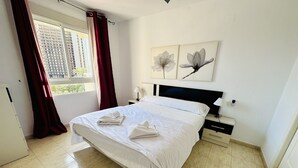 Une chambre d’hôtel avec un lit, une table de chevet, une lampe et des œuvres d’art accrochées au mur.