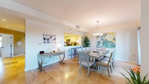 A modern kitchen with a central island, a dining area with a table and chairs, and a living space with a sofa and a coffee table. - 7169 Harbourside II with Beautiful Marina Views! (Hilton Head)