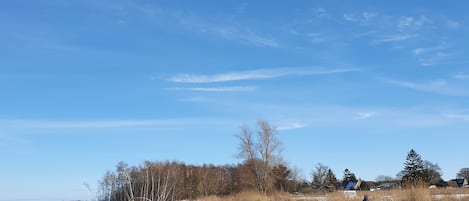 Un paysage hivernal, avec un ciel dégagé et une personne portant un pantalon jaune.